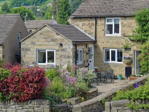 A stone house with a garden, a small table, and a bench. - 2 bedroom accommodation in Eyam, near Bakewell (Eyam, near Bakewell)