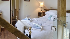 A bedroom with a wooden bed frame, a bedside table with a lamp, and a framed picture on the wall. - SHRUBBERIES COTTAGE - DC5472 (Old Liverton Village, near Staithes)