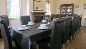 A formal dining room with a long table set for six, surrounded by black leather chairs. - 7 bedroom accommodation in Holme-on-Spalding Moor, near Market Weighton (Holme-on-Spalding Moor, near Market Weighton)