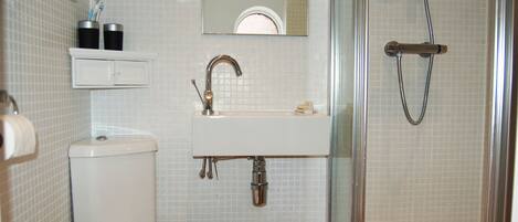 Ein Badezimmer mit Toilette, Waschbecken und Dusche.