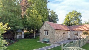A stone cottage with a red-tiled roof, a small garden, and a wooden gate. - 1 bedroom accommodation in Thornton le Dale near Pickering (Thornton le Dale near Pickering)