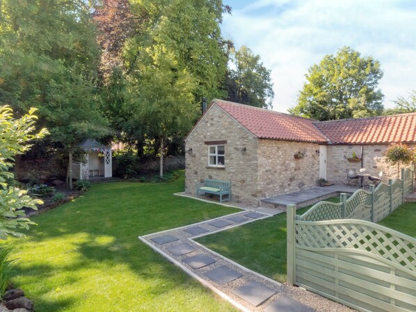 A stone cottage with a red-tiled roof, a small garden, and a wooden gate. - 1 bedroom accommodation in Thornton le Dale near Pickering (Thornton le Dale near Pickering)