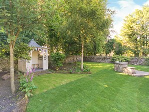 A garden with a gazebo, stone wall, and well-maintained grass. - 1 bedroom accommodation in Thornton le Dale near Pickering (Thornton le Dale near Pickering)