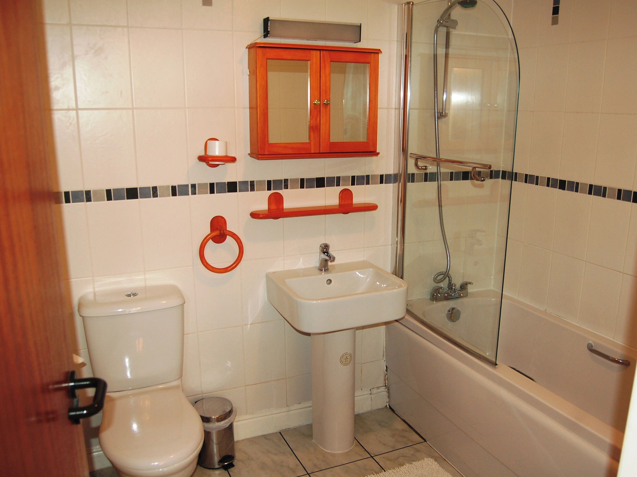 A bathroom with a toilet, sink, and shower.