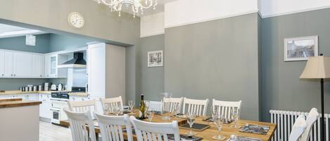 Eine moderne Küche mit weißen Schränken, einer Holz Arbeitsplatte und einem eingebauten Herd.