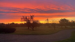 A sunset over a grassy field with a gravel path.