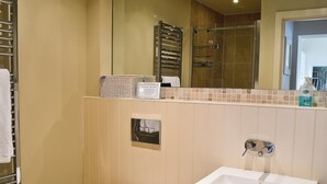 A bathroom with a toilet, a sink, and a shower area.