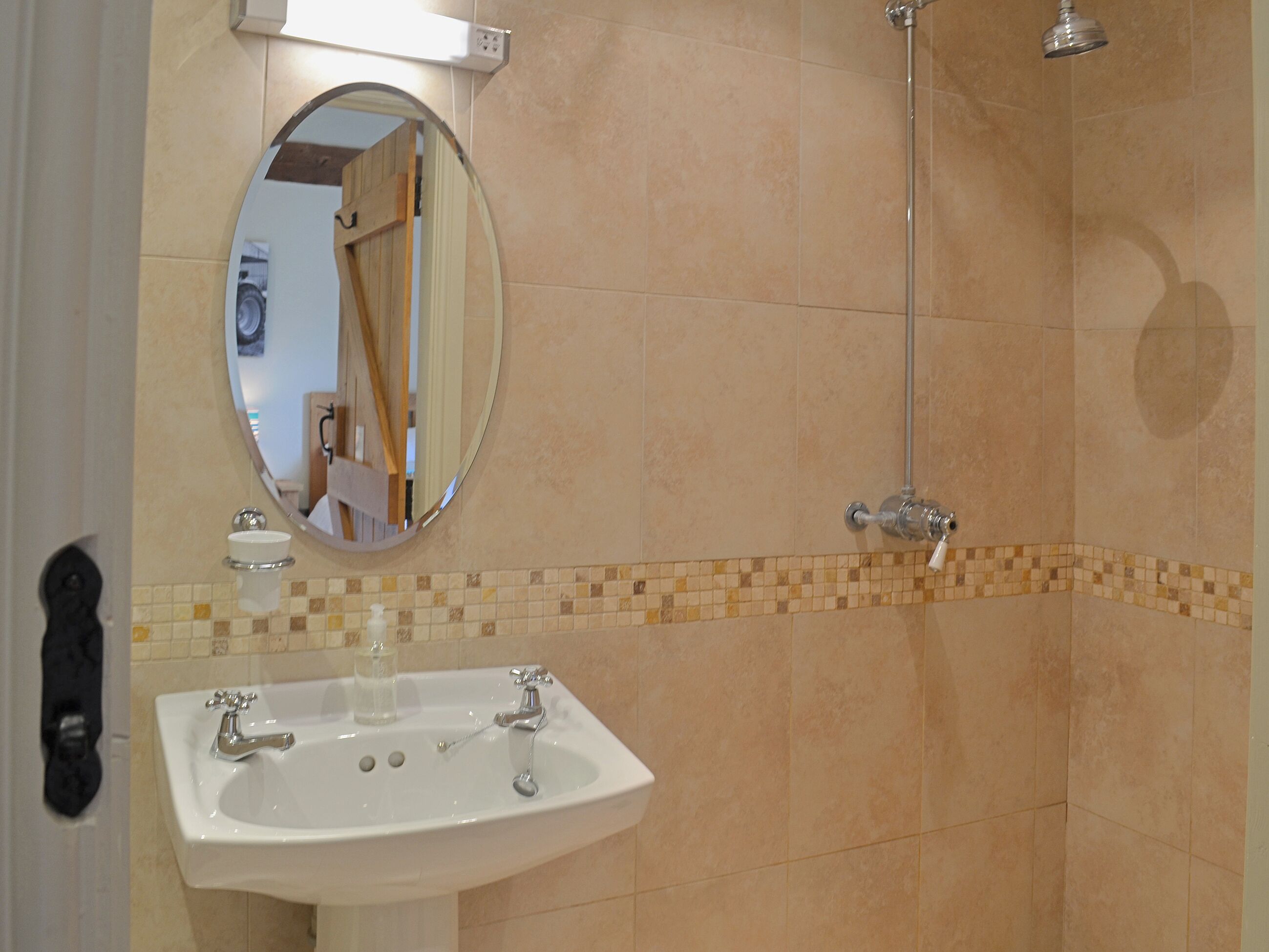 Ein Badezimmer mit Waschbecken, Spiegel und Dusche.