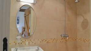 Un baño con lavamanos, espejo y ducha.