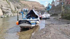 Un bateau baptisé « Margaret Elizabeth » était amarré sur une rive rocheuse, avec des bâtiments visibles en arrière-plan.