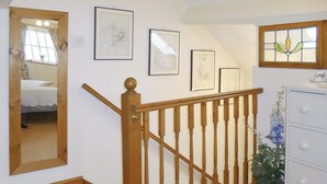 A staircase with wooden balusters and a handrail, a white dresser with drawers, and framed artwork on the walls. - 5 steps to entrance. (Burythorpe near Malton)