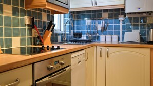Una cocina con microondas, estufa, horno y armarios.