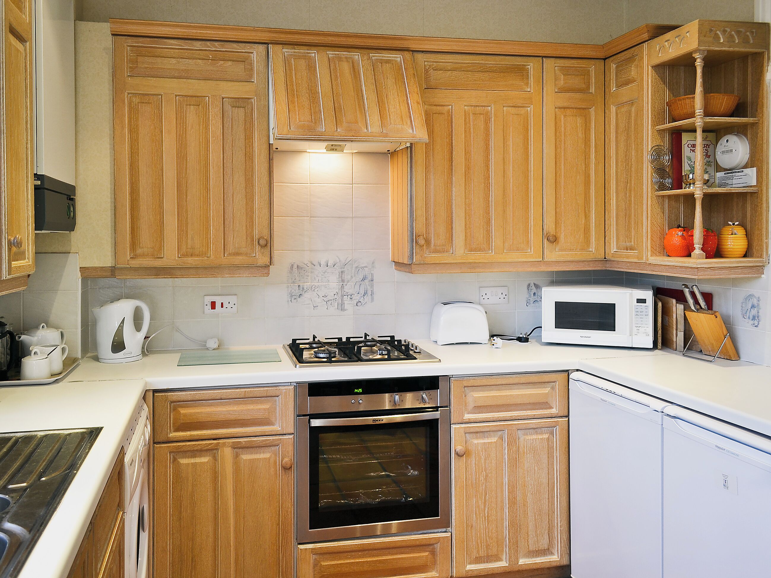 Une cuisine avec des meubles en bois, une cuisinière à gaz, un four à micro-ondes et un lave-vaisselle.
