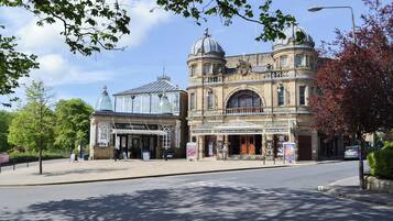 A historic opera house with a classical facade, large windows, and a prominent dome.