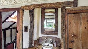 A rustic bathroom with a wooden vanity, a mirror, and a window. - 2 bedroom accommodation in Halesworth (Halesworth)