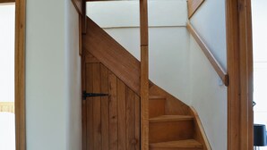 A wooden staircase with a handrail and a door at the bottom.