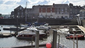 A harbor with boats docked, a stone wall, and buildings in the background. - 3 bedroom accommodation in Padstow (Padstow)