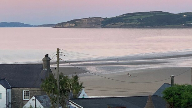 A coastal view with a beach, houses, and cliffs. - 3 bedroom accommodation in Benllech (Benllech)