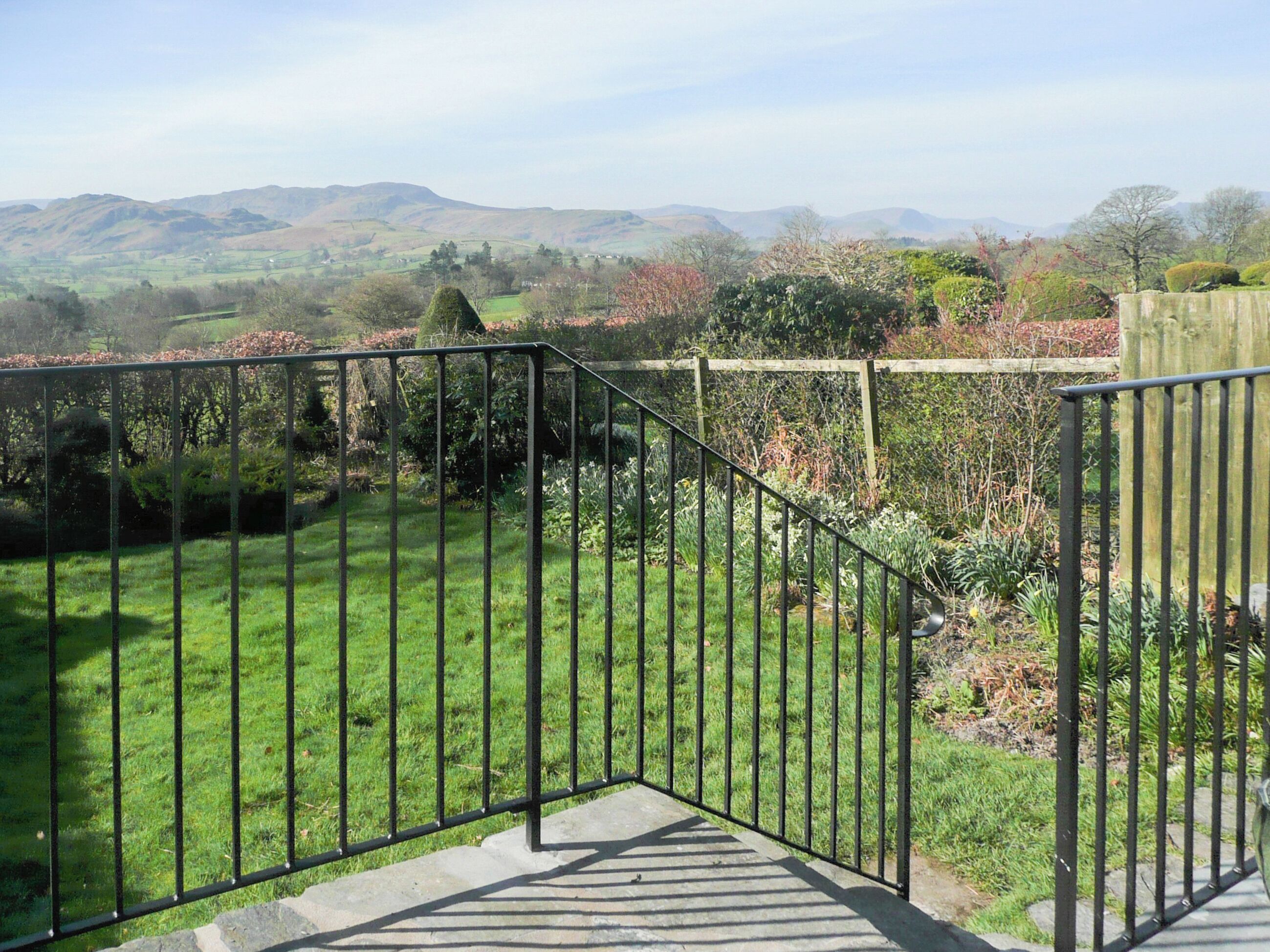 A garden with a metal staircase leading to a higher level.