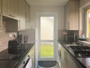 A modern kitchen with a dishwasher, sink, and a view of the outdoors. - 2 bedroom accommodation in Liskeard (Liskeard)