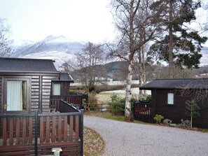 A cabin with a wooden deck and a gravel path leading to it. - 3 bedroom accommodation in Keswick (Keswick)