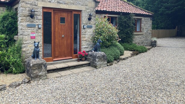 A stone cottage with a wooden door, a welcome sign, and a fox statue. - All on the Ground Floor: 
Open plan living space. (Lockton, near Pickering)