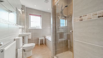 A modern bathroom with a toilet, sink, and shower area.