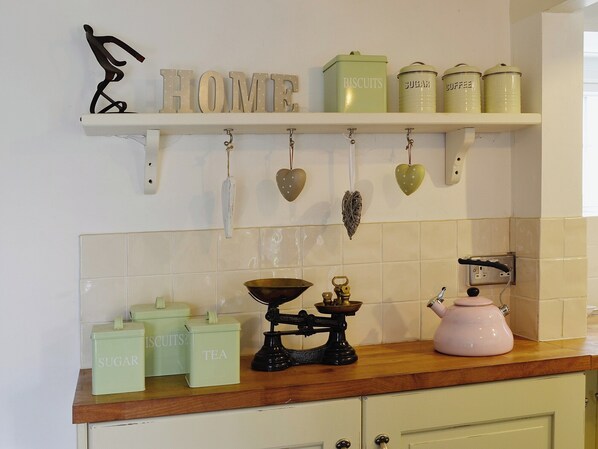 A kitchen with a shelf displaying kitchenware and containers labeled 'SUGAR', 'TEA', 'BISCUITS', 'SUGAR', and 'COFFEE'. - 3 bedroom accommodation in Helstone, near Camelford (Helstone, near Camelford)