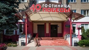 Un b âtiment à la façade rouge, sur lequel on peut lire l’inscription « 40 Гостиная ».