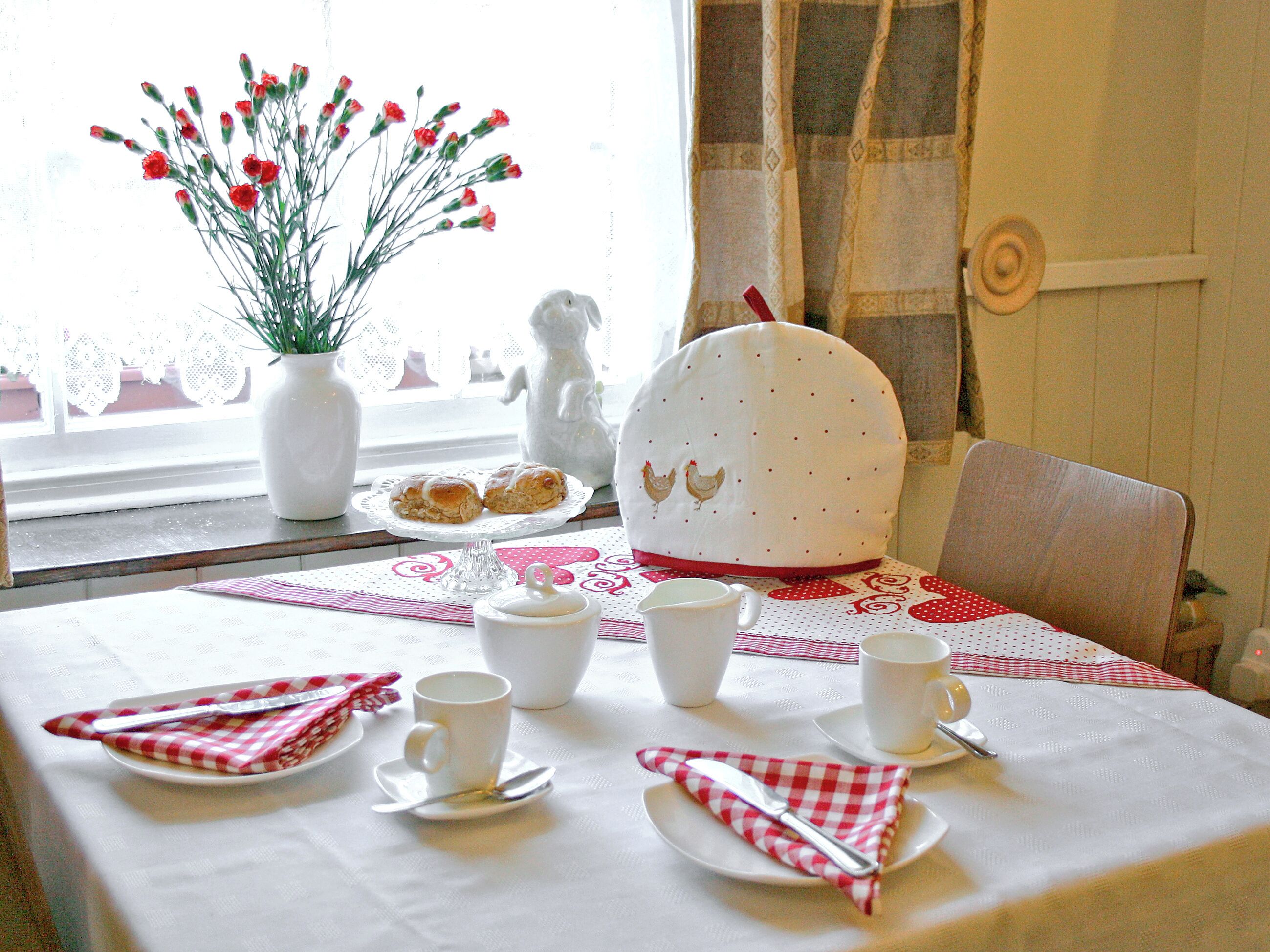 Une table à manger dressée avec des assiettes, des tasses et une théière.