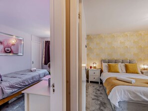 Ein Schlafzimmer mit Bett, Nachttisch und Beistelltisch.