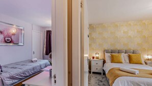 Une chambre à coucher avec un lit, une table de chevet et une commode.