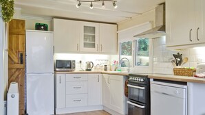 A kitchen with white cabinets, a microwave, a kettle, a sink, and a dishwasher. - 3 bedroom accommodation in Easthope, near Much Wenlock (Easthope, near Much Wenlock)