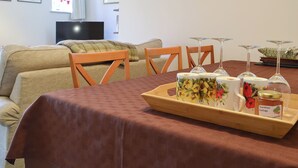 A cozy living room with a sofa, a dining table set with a tray of items, and a TV in the background. - 3 bedroom accommodation in Snettisham, near Hunstanton (Snettisham, near Hunstanton)