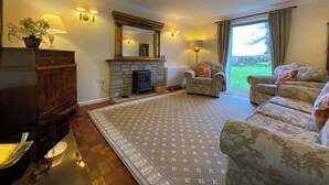 A living room with a fireplace, two armchairs, a sofa, and a large rug. - 3 bedroom accommodation in Misterton, near Crewkerne (Misterton, near Crewkerne)