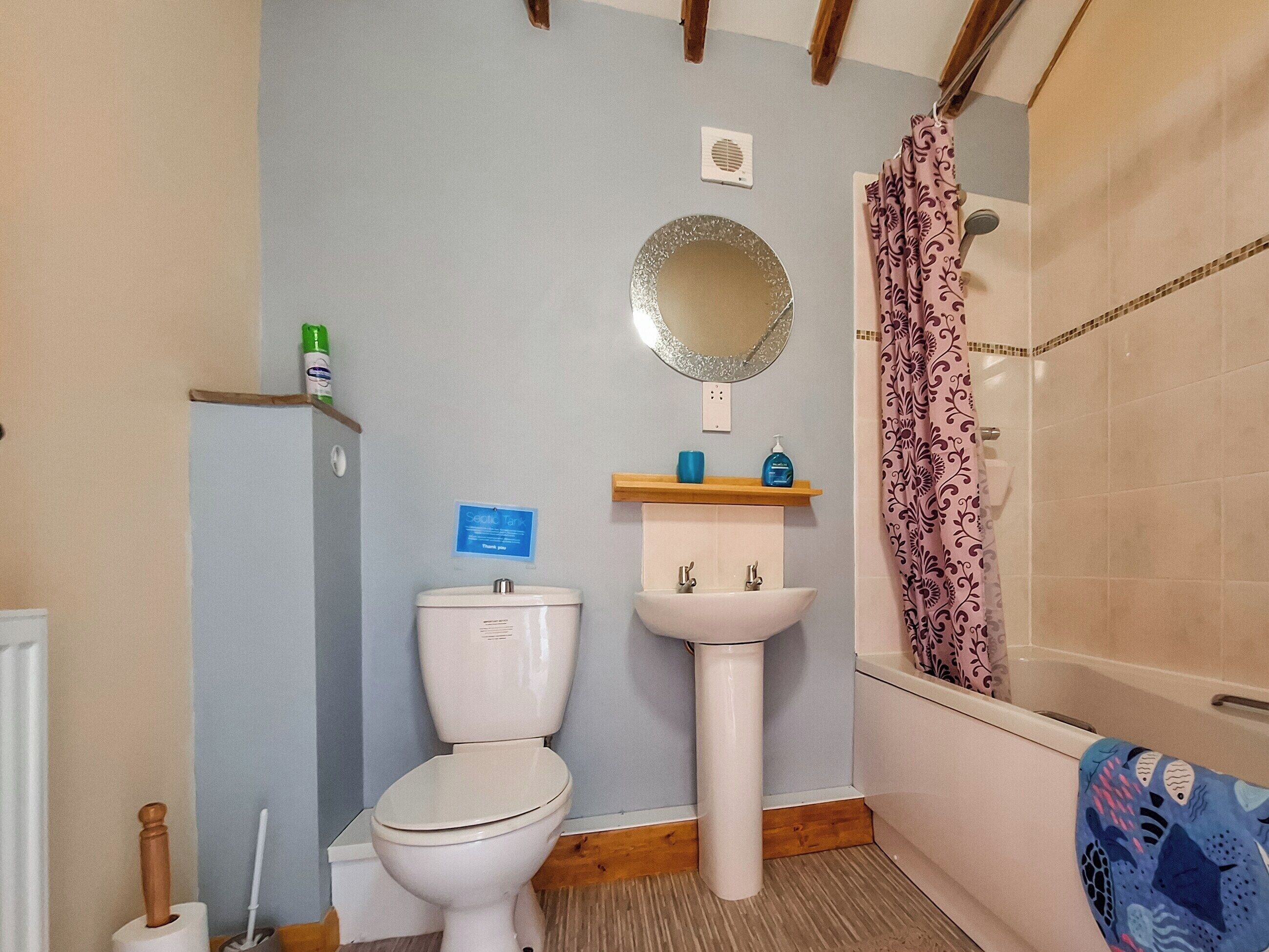 A bathroom with a toilet, sink, and shower.