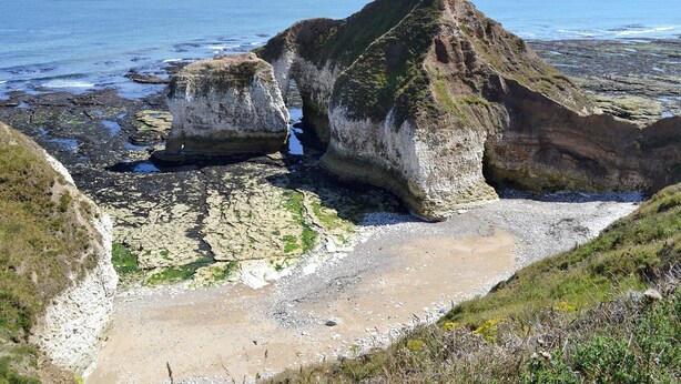 Un paysage côtier caractérisé par des formations rocheuses et une vue dégagée sur la mer.