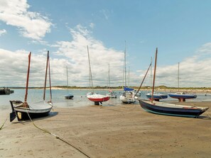 A sandy beach with several boats moored along the shore.