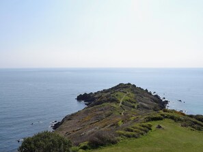 A coastal landscape with a grassy hill and a clear view of the sea. - 3 bedroom accommodation in Coverack, near Helston (Coverack, near Helston)