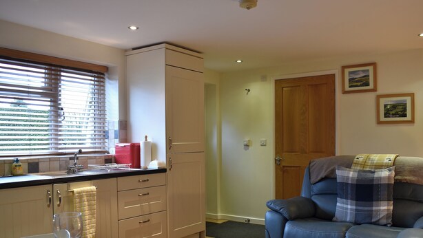 A compact living space with a kitchenette, dining area, and a seating area with a sofa and a blanket. - Explore North Yorkshire from this cosy, dog-friendly former stable near Thirsk. (South Kilvington near Thirsk)