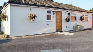 A single-story building with a tiled roof, a wooden door, and two windows. - Explore North Yorkshire from this cosy, dog-friendly former stable near Thirsk. (South Kilvington near Thirsk)