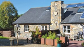 Un bâtiment en pierre avec un toit en pente, des panneaux solaires et une enseigne sur laquelle on peut lire : « The Old Grange ».
