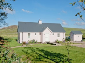 A two-story house with a grey roof, a white door, and a small attached garage. - 2 bedroom accommodation in Clachan near Tarbert (Clachan near Tarbert)