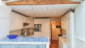A compact kitchen with white cabinets, a blue tiled countertop, and a solar-powered device. - 4 bedroom accommodation in Cleobury Mortimer, near Ludlow (Cleobury Mortimer, near Ludlow)