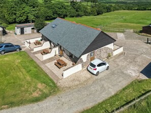 A two-story building with a stone facade, a flat roof, and a gravel driveway. - 1 bedroom accommodation in Hartland, near Bideford (Hartland, near Bideford)