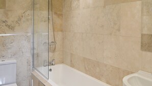 Ein Badezimmer mit Badewanne, Toilette und Waschbecken.