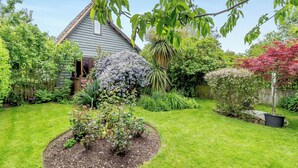 A well-maintained garden with a variety of plants and a house in the background. - 2 bedroom accommodation in Woodbridge (Woodbridge)