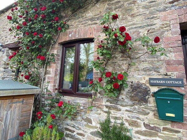 A stone cottage with a sign reading "Haybarn Cottage" and a green mailbox. - 2 bedroom accommodation in Fowey (Fowey)