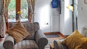 Un salon chaleureux avec des canapés à rayures, une table basse en bois et une lampe.