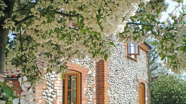 Un bâtiment en pierre avec une façade en briques, une porte en bois et une fenêtre.